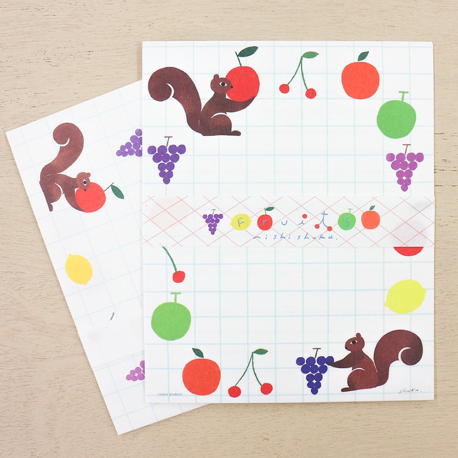 Juego de cartas con frutas, papeles y sobres para escribir