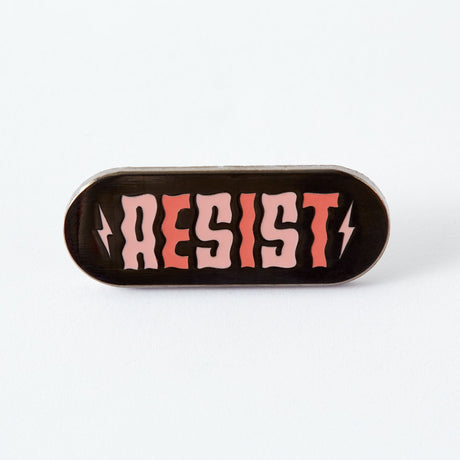 If they think we’re going to take their shit lying down, they can think again. Now is the time to resist. To fight back. To protest. To tell politicians and power trippers where to put their vitriol. And when we are lying down (because we all need a break) we’ll be wearing this pin.